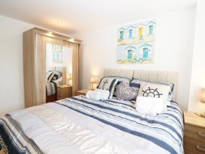 a bedroom with a large bed with blue and white sheets at 7 Ocean Gateway in Hythe
