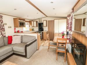 sala de estar con sofá y cocina en 18 Lake View en Cawston