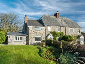 una grande casa in pietra con un prato di 2 Bittadon Cottages a Barnstaple