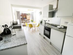 a kitchen with white appliances and a dining room at 25 Shakespeare Street in Stratford-upon-Avon