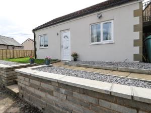 a house with a retaining wall and a driveway at The Button Box in Huddersfield
