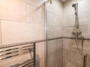 a shower with a glass door in a bathroom at Lilac Cottage in Great Malvern