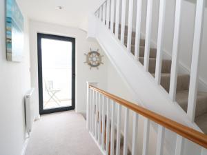 a staircase with white walls and a white stair case at 7 Ocean Gateway in Hythe