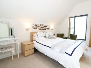 a white bedroom with a large bed and a desk at 7 Ocean Gateway in Hythe