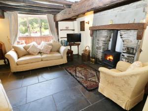 a living room with a couch and a fireplace at Rose Cottage in lower hawthwaite