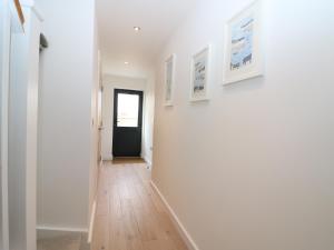 a hallway with white walls and a black door at 7 Ocean Gateway in Hythe