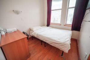 a small room with a bed and a desk and a window at U.S. Pacific Hotel in New York