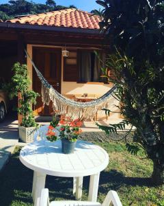 聖佩德羅達塞拉的住宿－Cantinho da Paz，房子前面的一张桌子上的吊床