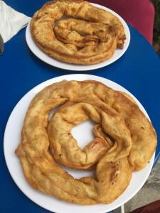 two plates of onion rings sitting on a table at Mando Beachfront in Stafylos