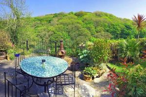 a patio with a table and some plants at Central Boscastle studio flat in Boscastle