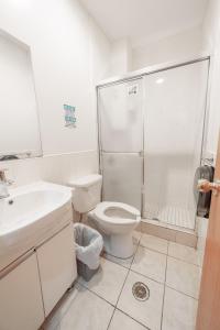 a white bathroom with a shower and a toilet at U.S. Pacific Hotel in New York