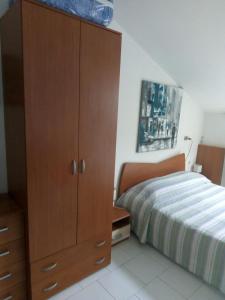 - une chambre avec une grande armoire en bois à côté d'un lit dans l'établissement Monolocale Stella, à San Benedetto del Tronto