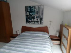 - un lit dans une chambre avec une photo sur le mur dans l'établissement Monolocale Stella, à San Benedetto del Tronto