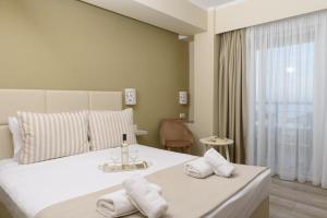 Кровать или кровати в номере Ammos Beach Seaside Luxury Suites Hotel