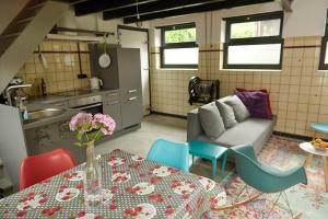 a kitchen and living room with a table and a couch at Bed in Beek in Beek