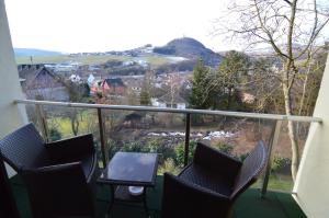 einen Balkon mit Stühlen, einem Tisch und Aussicht in der Unterkunft Landhotel Maarheide in Niederdürenbach