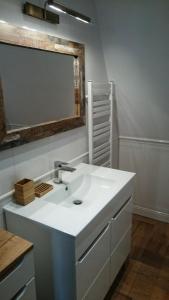 een badkamer met een witte wastafel en een spiegel bij Villa Bri in Łeba