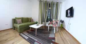 a living room with a green couch and a table at Green Apartments Bjelašnica in Bjelašnica
