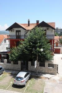 a car parked in a parking lot in front of a house at Apartments Erakovic in Nikšić