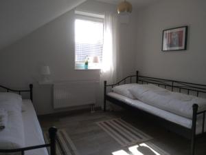 Hartenholm的住宿－Pension Holmer Moorhof，一间卧室设有两张床和窗户。
