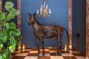 eine Statue eines Pferdes auf einem Boden neben einem Kronleuchter in der Unterkunft Grand Ferdinand Vienna – Your Hotel In The City Center in Wien