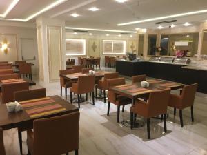 un ristorante con tavoli e sedie in legno e un bancone di Laleli Gonen Hotel a Istanbul