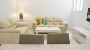 a living room with two couches and a coffee table at Ivory Suite Valletta in Valletta