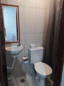 La salle de bains est pourvue de toilettes, d'un lavabo et d'un miroir. dans l'établissement Pousada Casa da Lucinha, à Fortaleza