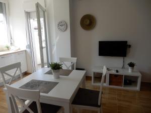 a living room with a white table and a tv at Summer apartment in Bar