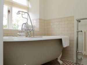 een badkamer met een bad en een wastafel bij The Plough Inn in Little Faringdon