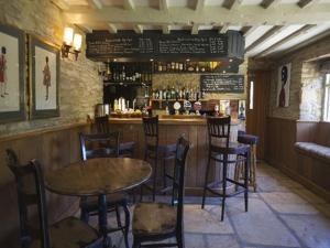 a bar with a table and chairs in a restaurant at The Plough Inn in Little Faringdon