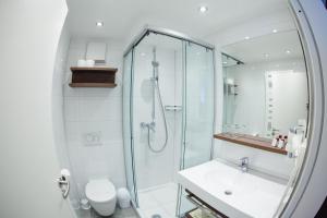 a bathroom with a glass shower and a sink at HIRSCH 1783 Hotel LANDHAUS in Langenargen +35 photos