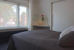 - une chambre avec un lit et une grande fenêtre dans l'établissement Het Huis tussen Kerk en Klooster, à Ootmarsum