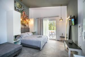 1 dormitorio con cama, sofá y ventana en Venice Deluxe Studios en Pefkari