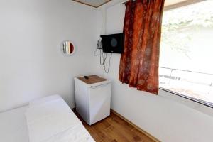 a small room with a bed and a window at Бунгала Калина - Нестинарка in Tsarevo +7 photos