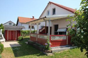 a house with a red fence and a yard at Haus Sonne,Seeblick 57 in Boiensdorf