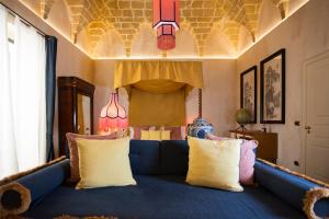 a living room with a blue couch with pillows at Palazzo Presta in Gallipoli