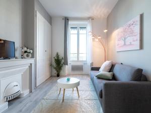 ein Wohnzimmer mit einem Sofa und einem Couchtisch in der Unterkunft Macé Studio Apartment in Lyon