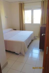 a bedroom with a bed and a window and a tiled floor at Pl Les Bovetes Apt in Denia
