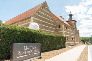 a building with a sign in front of it at Martin's Rentmeesterij in Bilzen