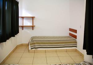 a bed sitting in a corner of a room at Chales do Velho Chico in Três Marias