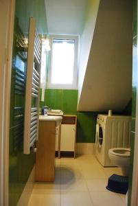 ワルシャワにあるApartament - Chelmskaのバスルーム(トイレ、洗面台付)、窓が備わります。