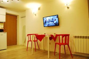 ワルシャワにあるApartament - Chelmskaのリビングルーム(テーブル、赤い椅子4脚付)