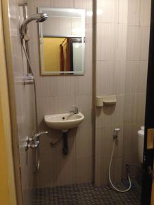 een badkamer met een wastafel en een spiegel bij Sekumpul BnB in Singaraja