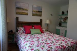 Gite L'Antre d'Eux في شيربروك: غرفة نوم بسرير ومخدات حمراء وأخضر