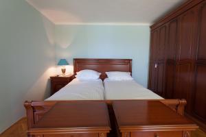 a bedroom with a bed with a wooden headboard and a table at House Pelcic Kostrena in Kostrena