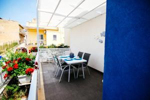 a patio with a table and chairs and flowers at Crimìa Holidays in Marina di Ragusa