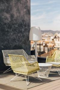 a row of chairs sitting on top of a wooden table at Hotel Bagués, a Small Luxury Hotel of the World in Barcelona