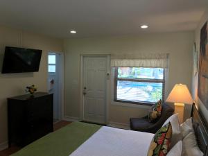 a bedroom with a bed and a chair and a window at Harborside Motel & Marina in Key West