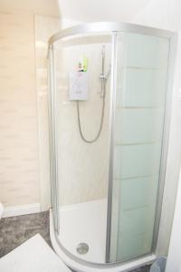 a shower with a glass enclosure in a bathroom at Bradford serviced apartments in Bradford